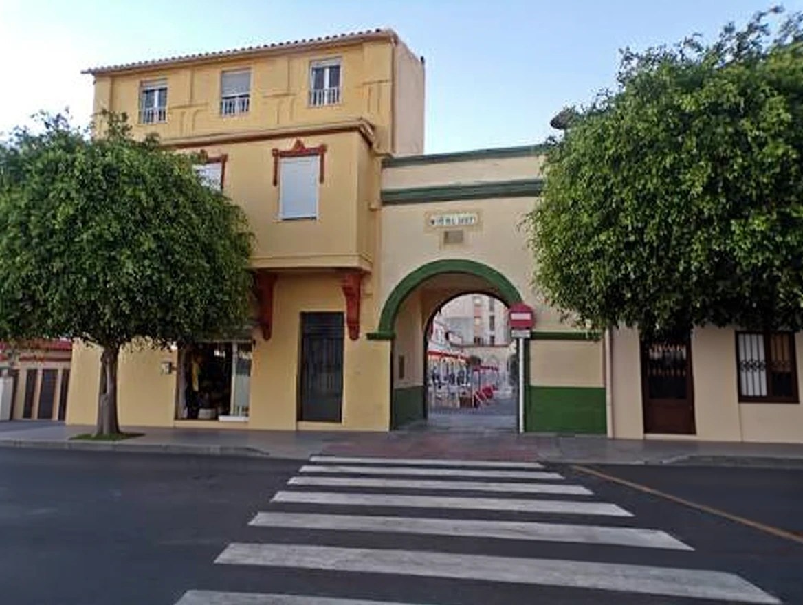 La fachada amarilla de la sede junto al arco verde de la plaza Rafael Gibert, en Ceuta
